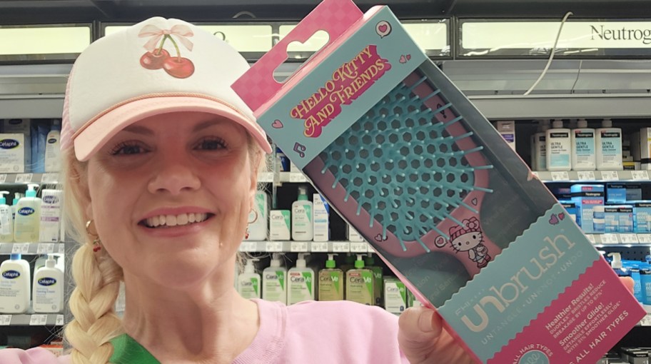 woman holding up hello kitty hair brush in store