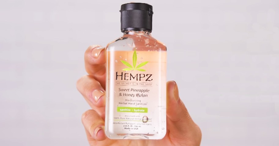 hand holding up a bottle of Hempz Sweet Pineapple & Honey Melon Hand Sanitizer