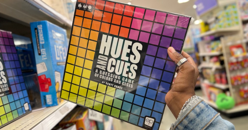 Person holding up hues and cues board game inside target store