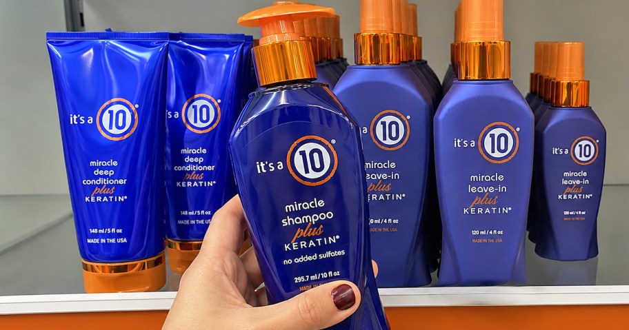 hand holding orange and blue It's A 10 Miracle Shampoo Plus Keratin bottle in store