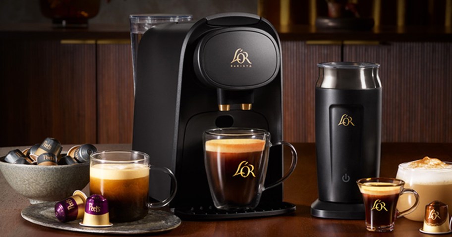 black espresso machine and frother on counter with coffee pods