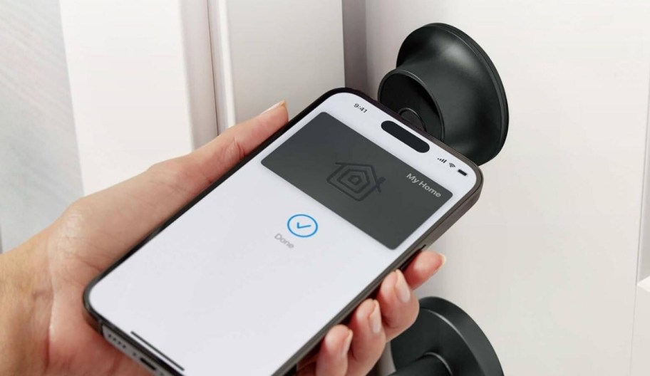 a person unlocking their door with their phone help up to a smart deadbolt
