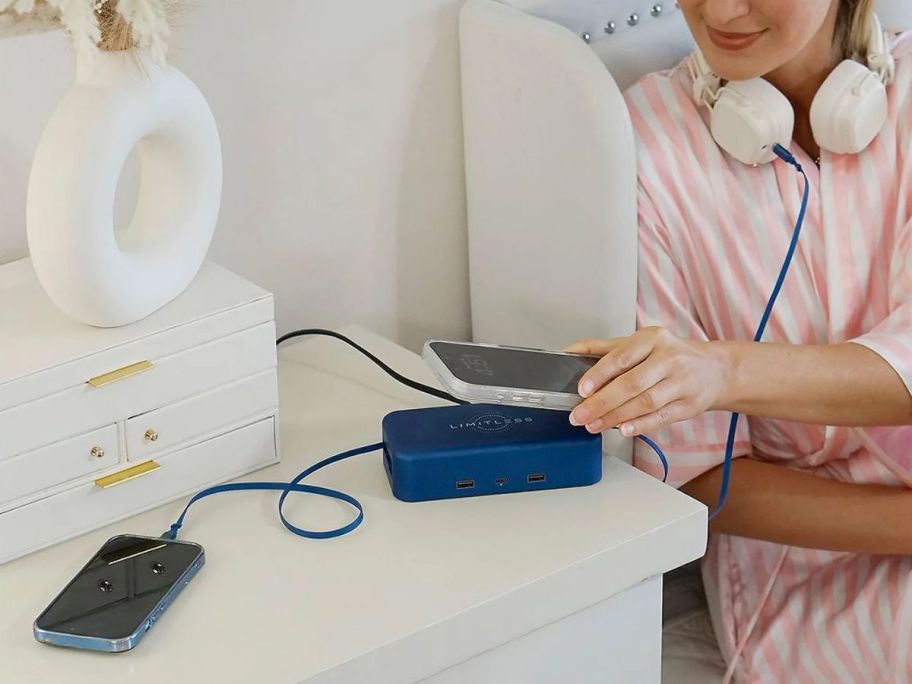 A woman using a Limitless power bank to charge multiple devices