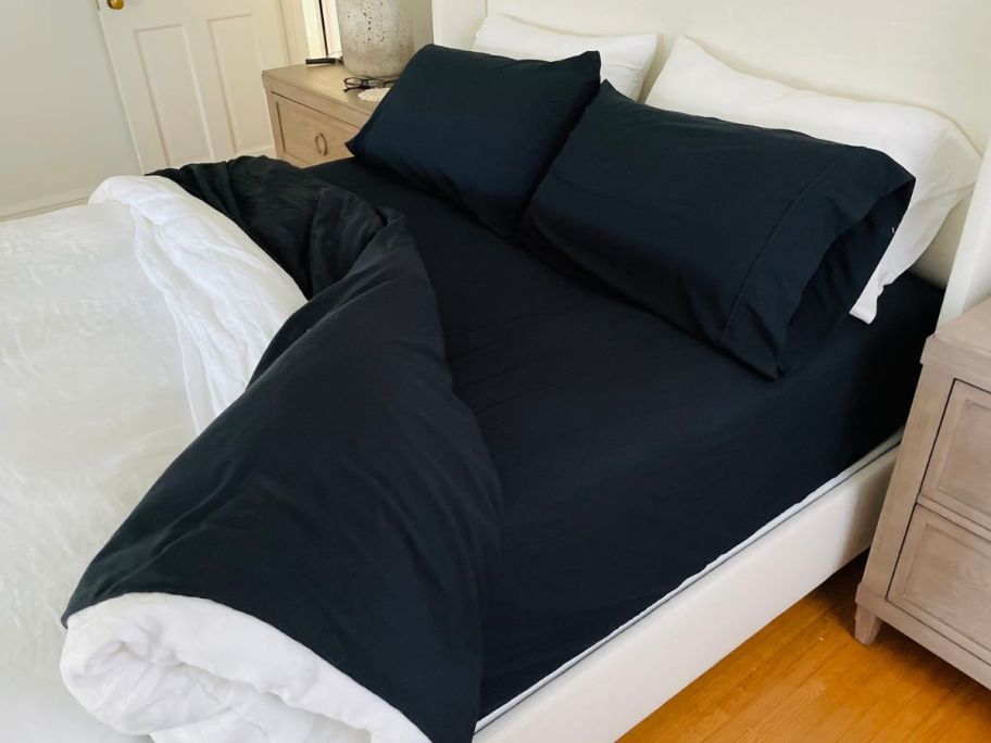 A bed with black Linens & Hutch Sheets