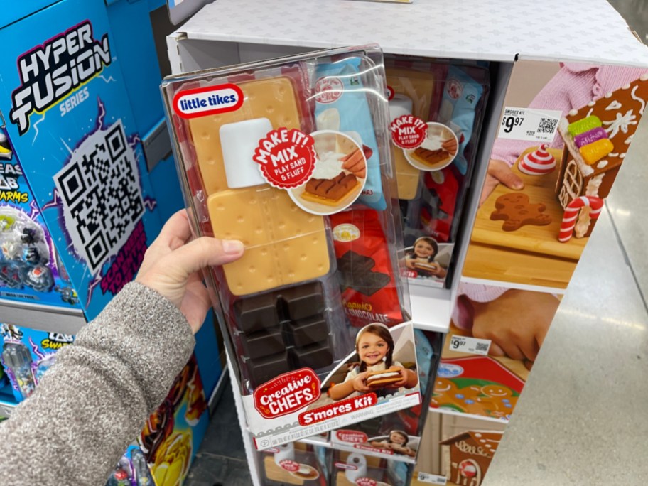 A hand holding up a Little Tikes Creative Chefs Smores playset box.
