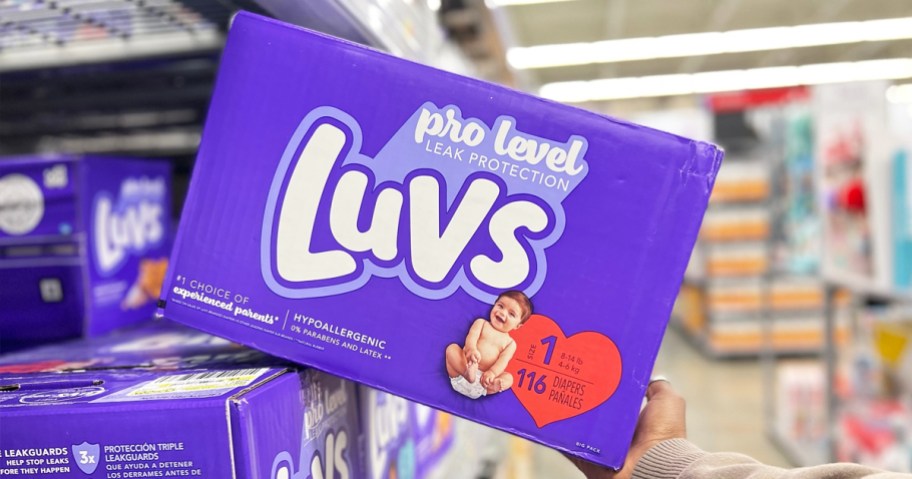hand grabbing a box of size 1 luvs diapers from store shelf