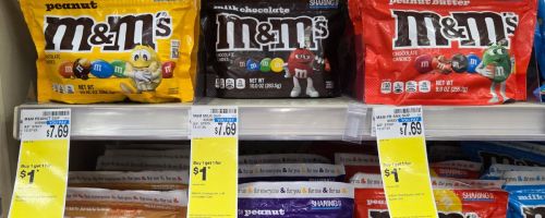 Several large M&M bags on a shelf in a store