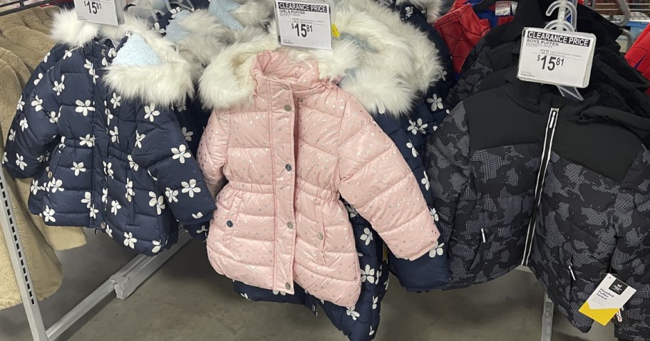 sam's club kids coats hanging in store with clearance sign