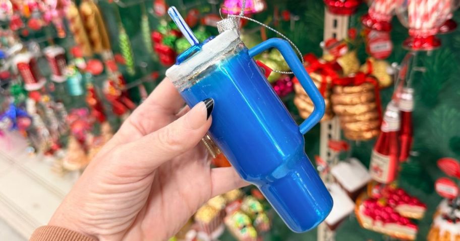 Hand holding a blue glass tumbler christmas ornament from Michaels