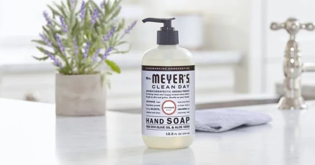 Bottle of Mrs. Myers, lavender scented hand soap on white countertop in front of lavender plant
