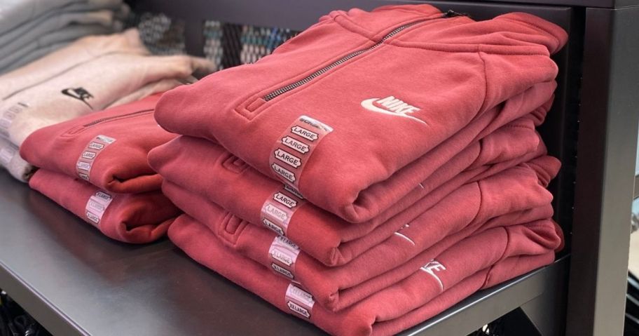A stack of folded Nike hoodies