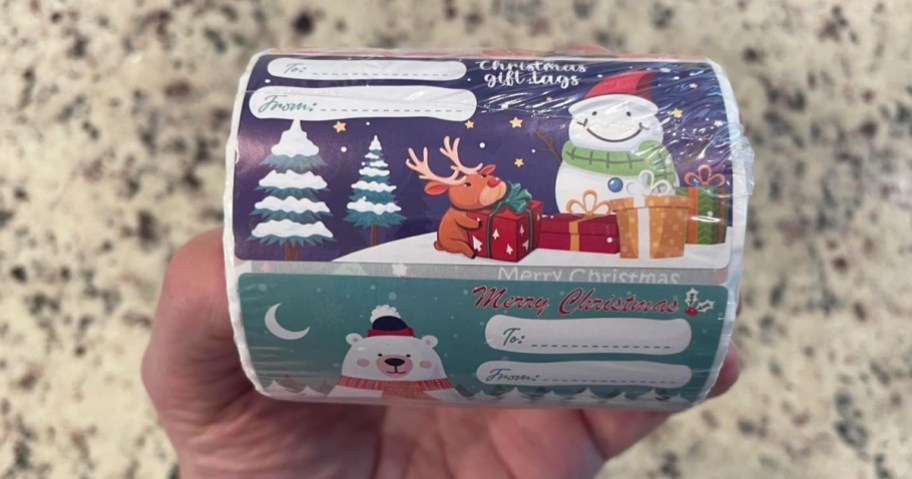 hand holding a large roll of christmas gift tags