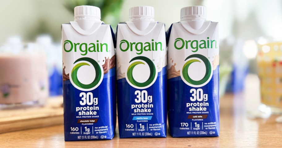 3 Orgain protein shakes in a row on a counter