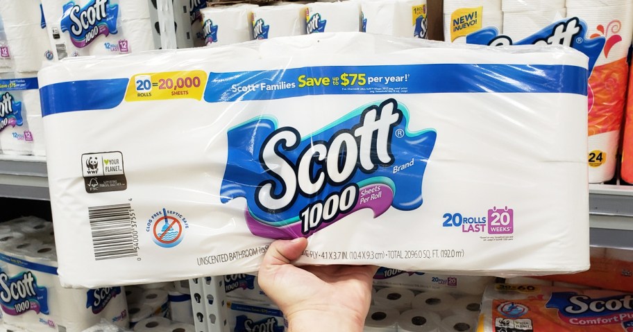hand holding up a large pack of scott 1,000 toilet paper