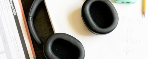 pair of black headphones on schoolwork