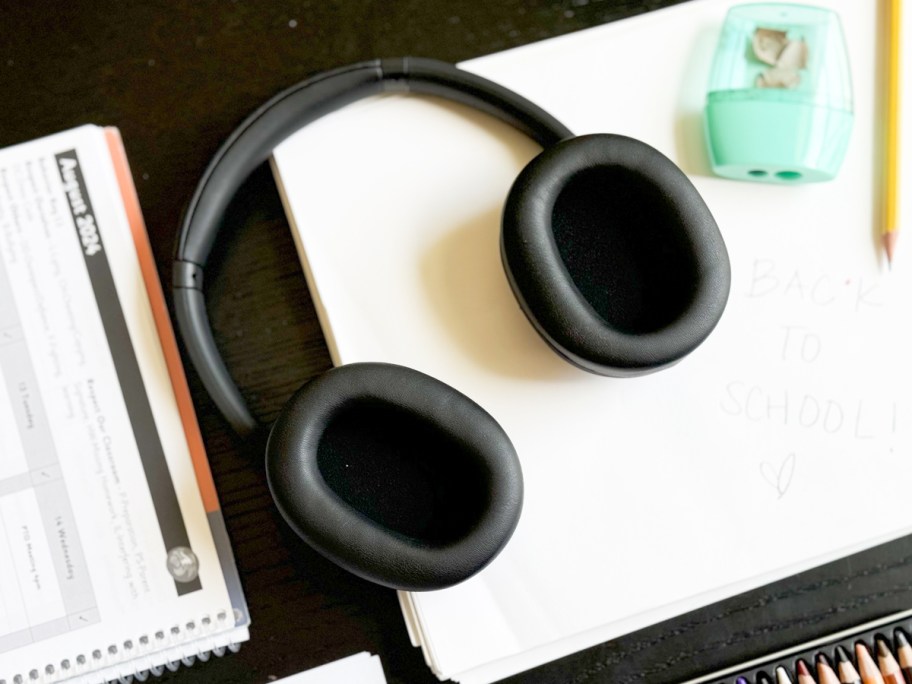 pair of black headphones on schoolwork