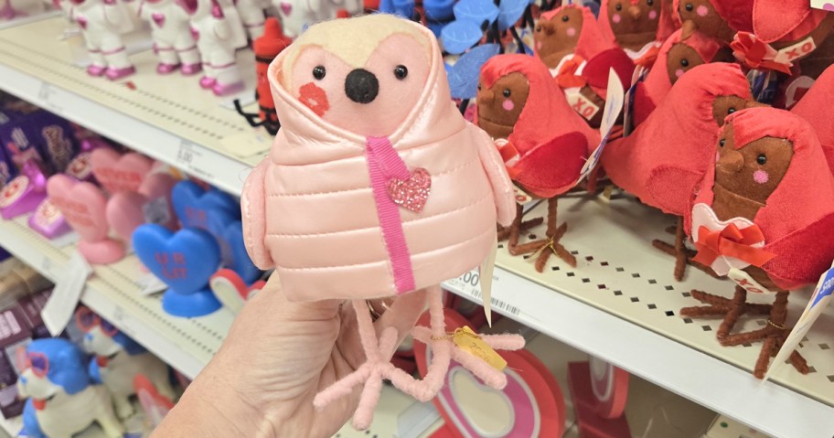 hand holding up a felt bird in a pink puffer coat