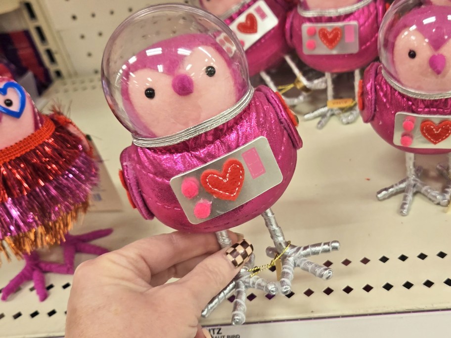 hand holding up a pink astronaut felt bird