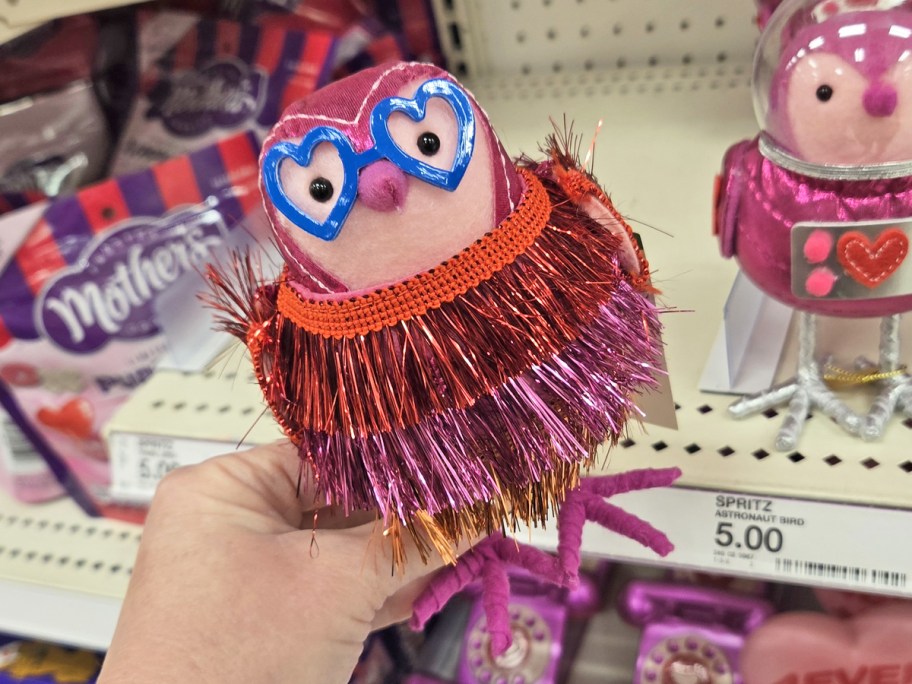 hand holding up a pink tinsel felt bird