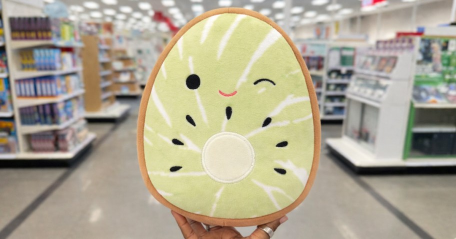 hand holding up a kiwi squishmallows plush in store
