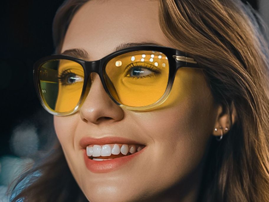 A smiling woman wearing yellowish glasses