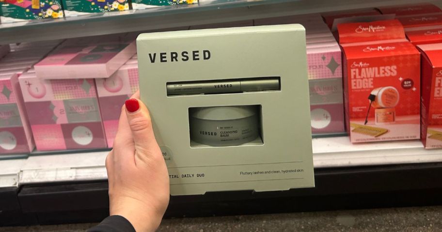 A person holding a green Versed gift set in a store