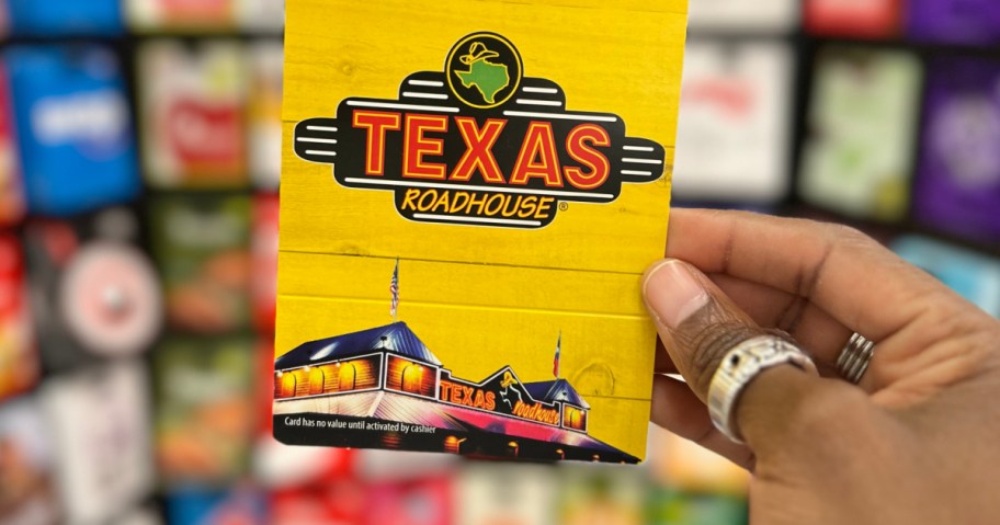 Woman holding up yellow Texas roadhouse gift card