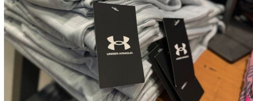 A stack of Under Armour clothing with tags on it