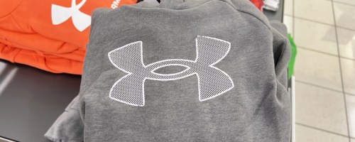 folded grey under armour hoodie on store display table