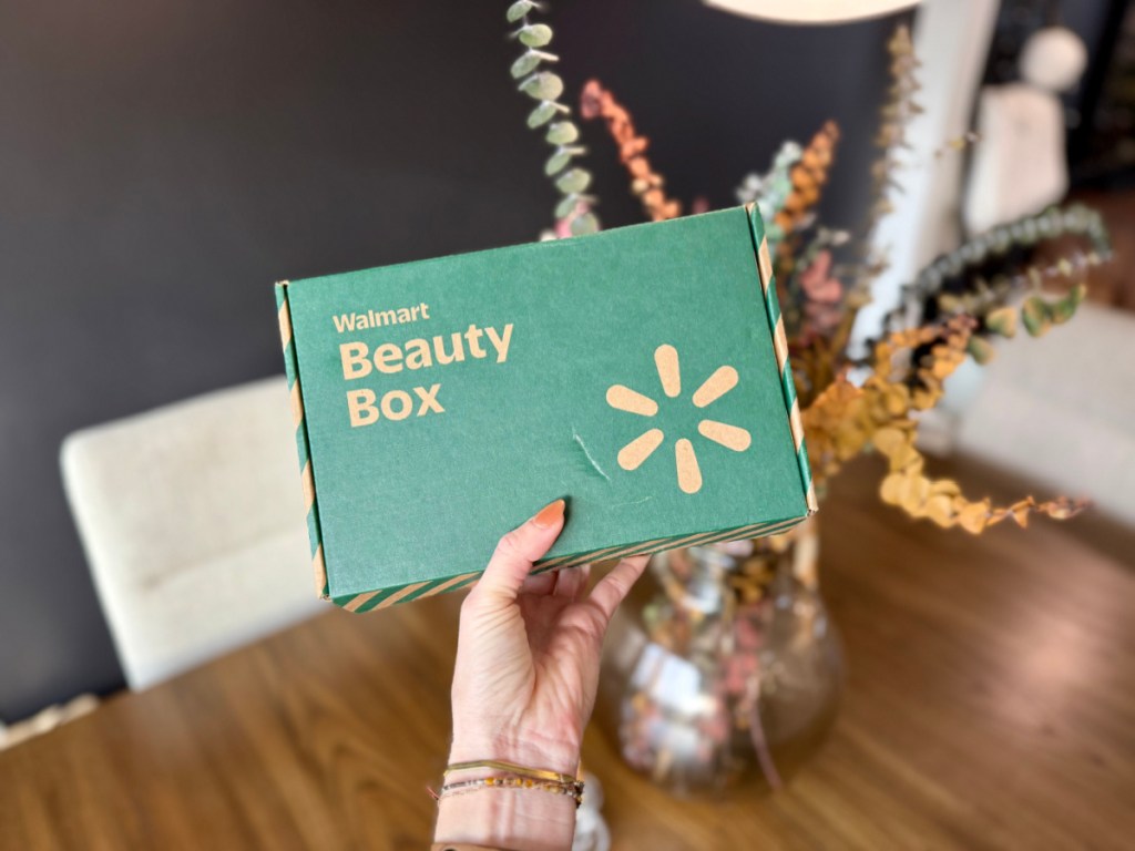 Woman holding up green Walmart beauty box