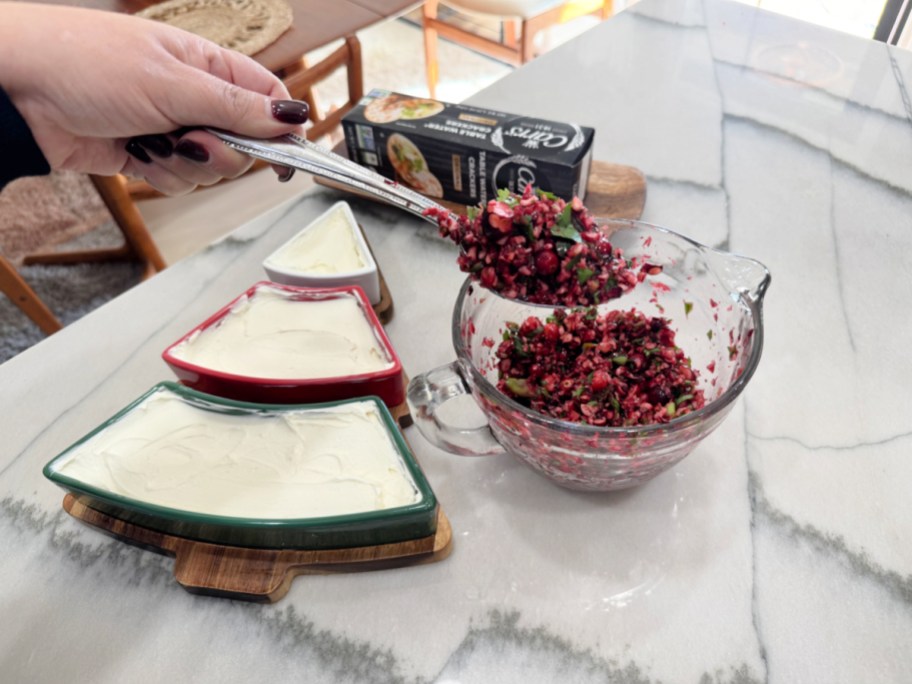 adding cranberry salsa to cream cheese