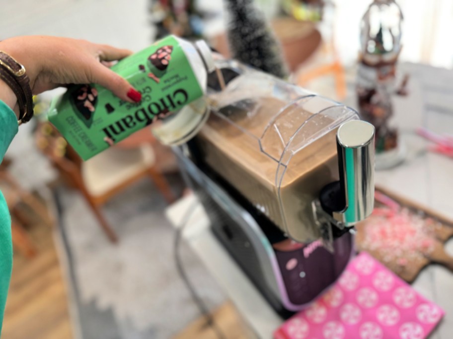 adding ingredients to ninja slushie for a holiday drink