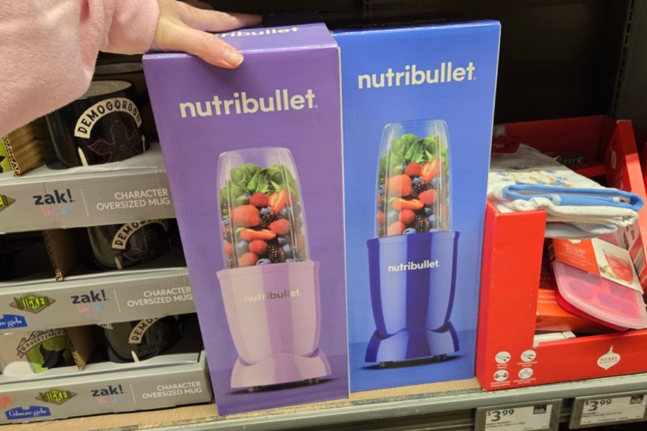 hand grabbing purple and blue personal blenders in store