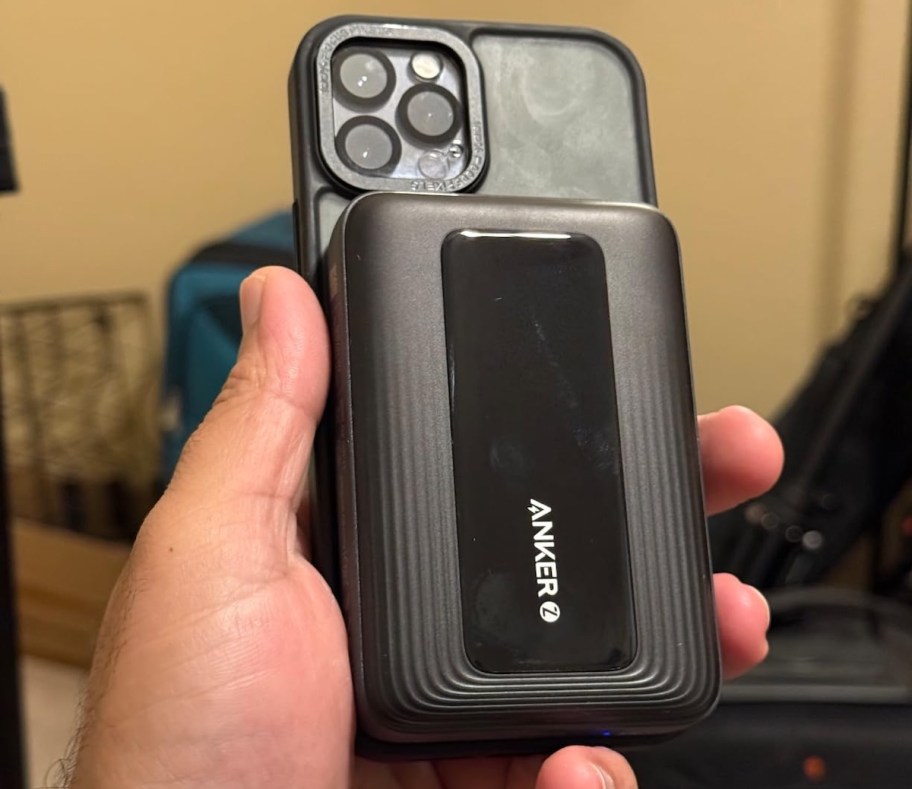 hand holding iphone with anker portable charger on magsafe on back