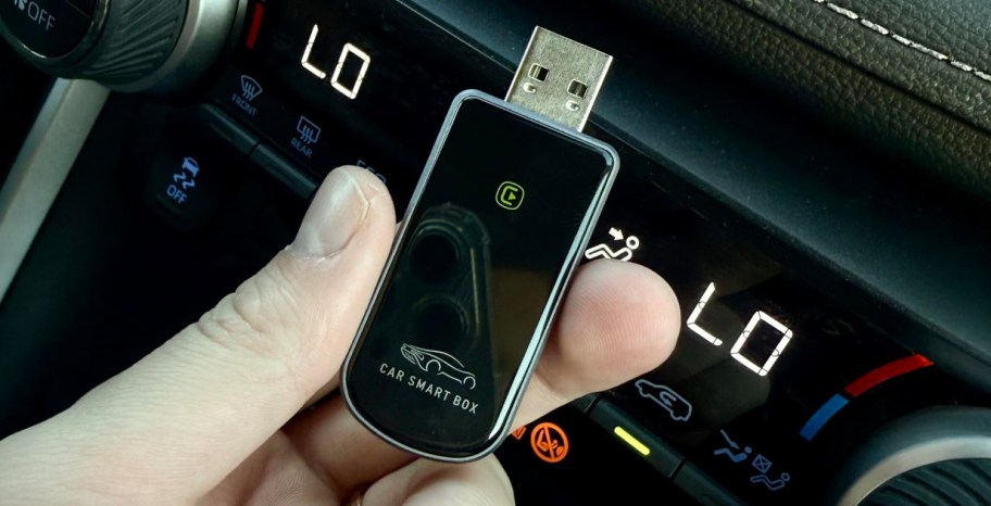 hand holding an apple car play dongle