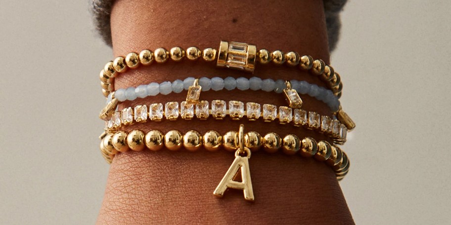 wrist with gold beaded bracelets