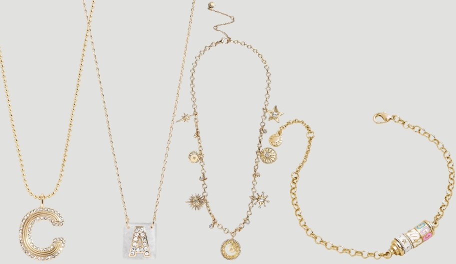 two initial necklaces in different styles shown with celestial themed necklace and custom spinner bracelet
