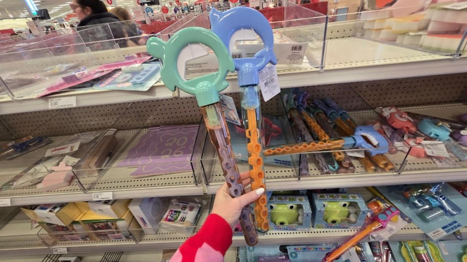 womans hand holding 2 giant bubble wands