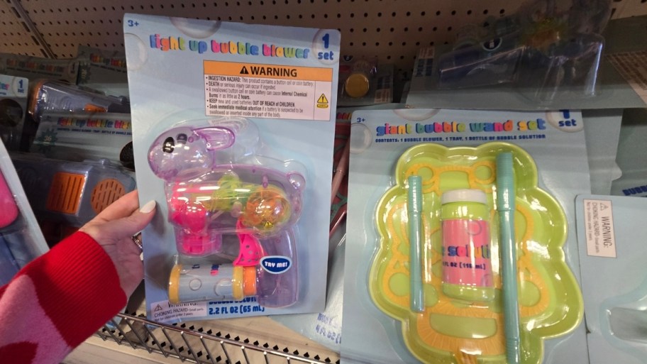womans hand holding a bubble blaster next to a bubble wand set