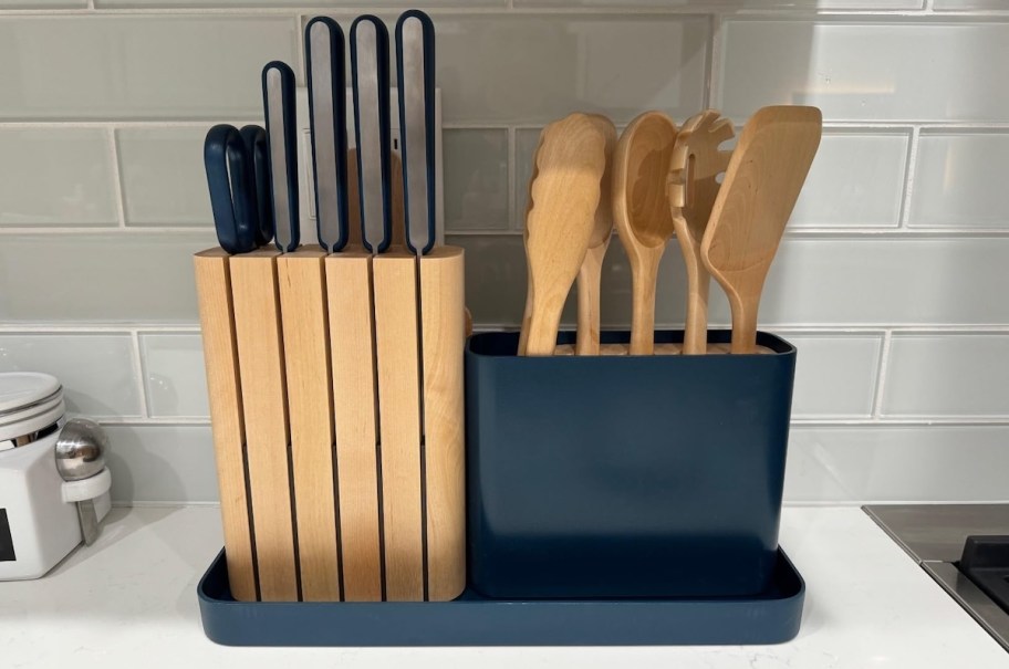 wood and navy organized knife and utensils on kitchen countertop