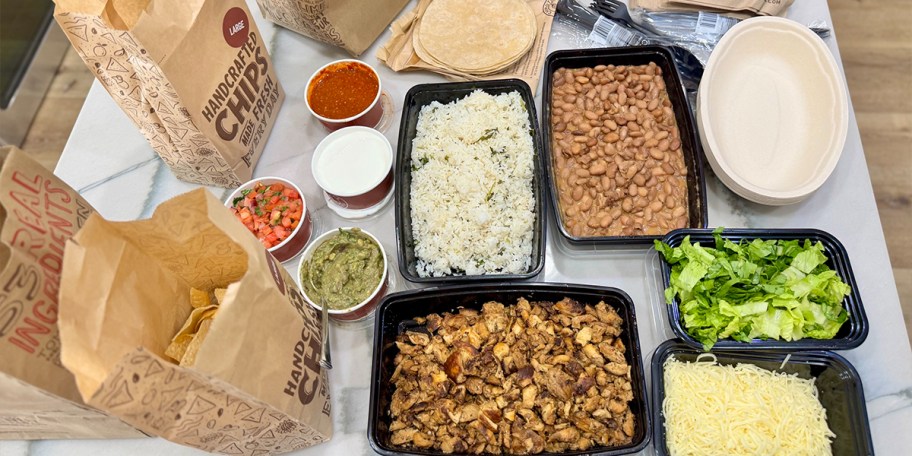 chicken, rice, beans, and sauces with chips on table 