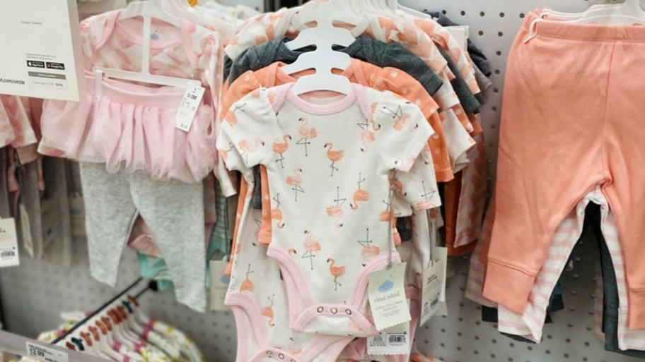 baby bodysuit 4 pack and joggers 3 pack on a display wall in a store