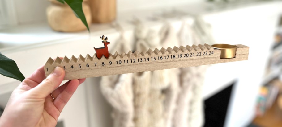 hand holding a wooden coundtown with reindeer