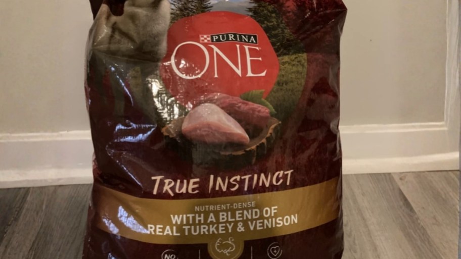a bag of dry dog food sitting on a hardwood floor