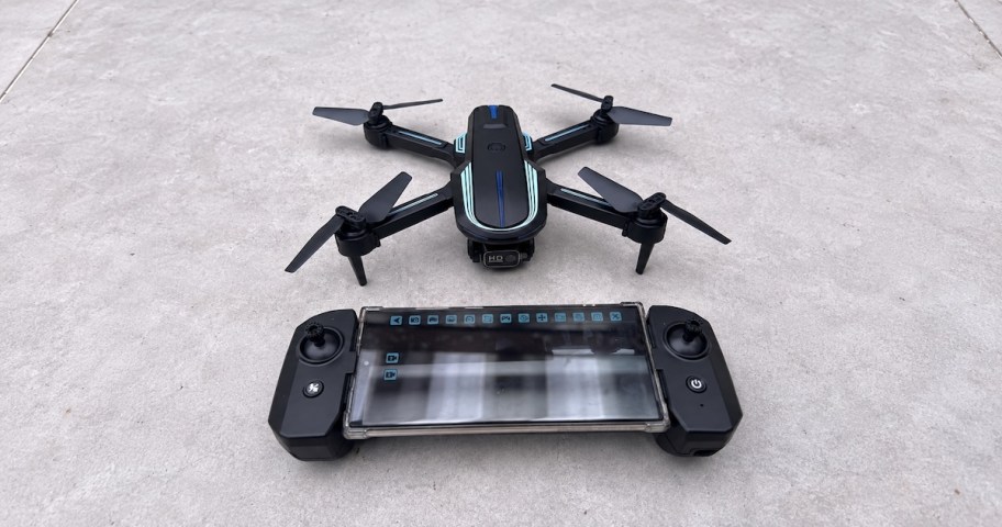 drone and remote with phone on sidewalk