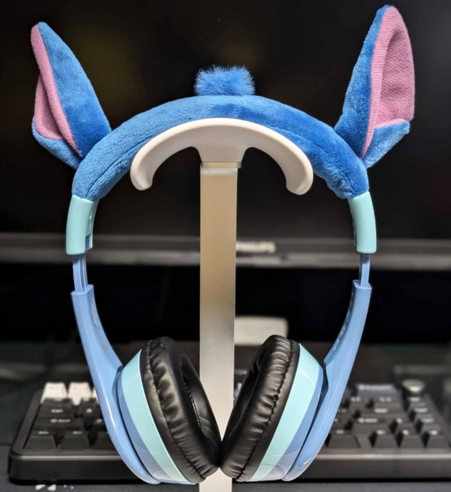 blue headphones with stitch ears on a headphone stand