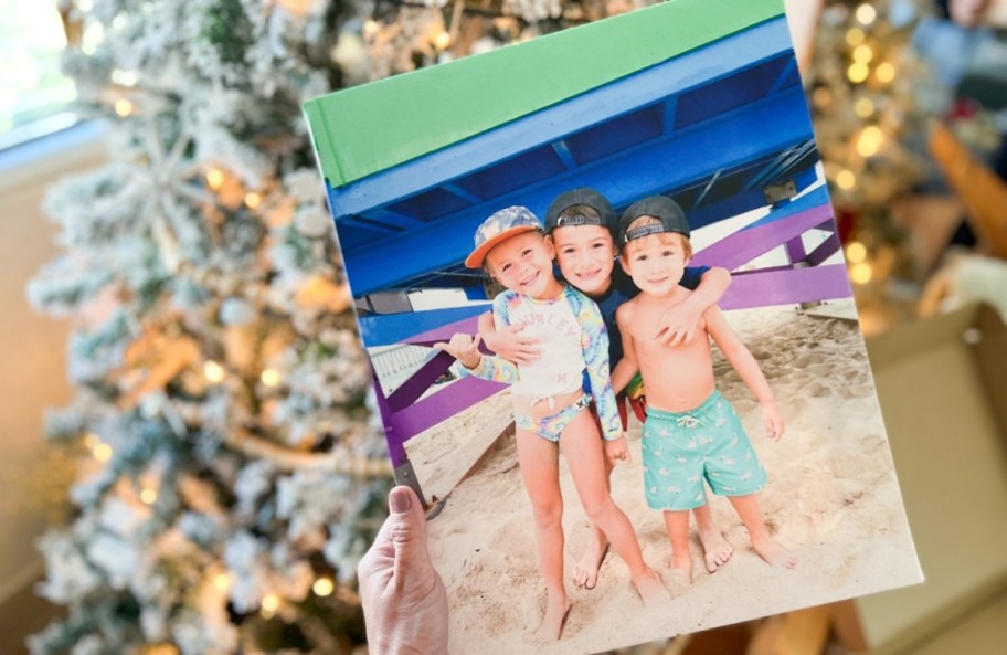 a womans hand holding a photo canvas