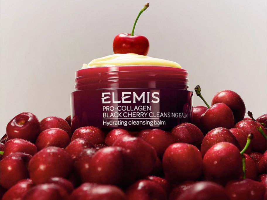 ELEMIS black cherry skincare on top of a pile of cherries.