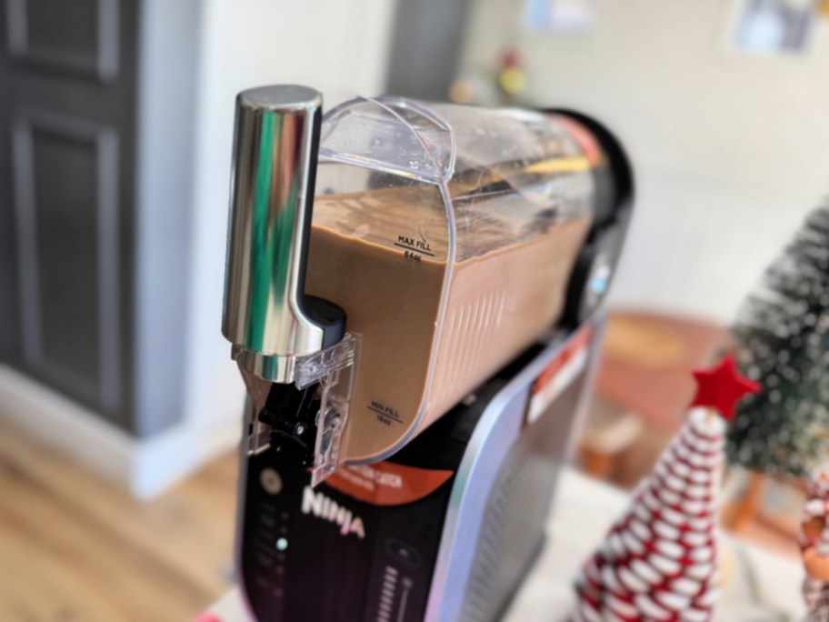 filling a ninja slushie with ice coffee and coffee creamer