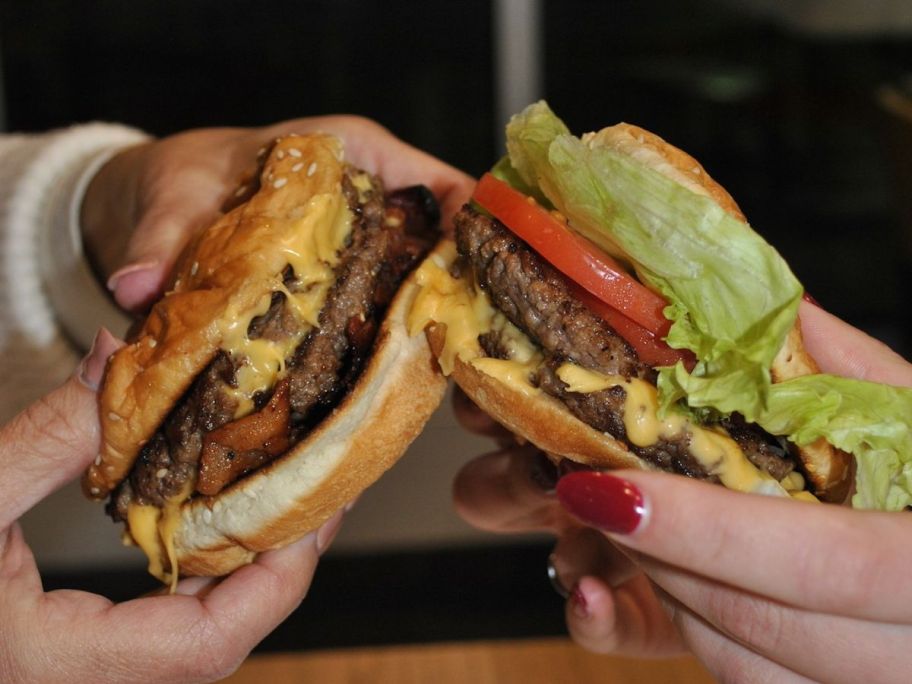 two people holding five guys burgers